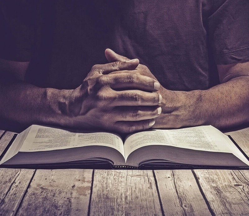 Temporary placeholder for an open King James Bible and prayer photograph